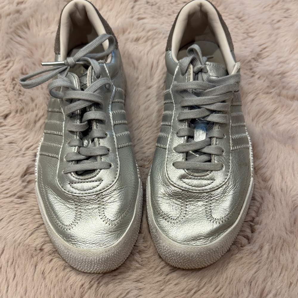 Silver metallic adidas Samba sneakers.